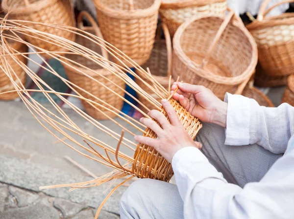 Adamın elleri bir hasır sepet yapım