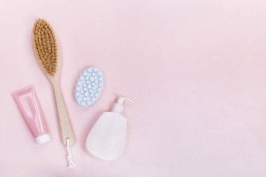 Spa products: soap,body brush,body cream over pink background 