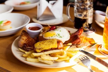 Aperatifli bira seti, kızarmış sosis, kraker, cips, tavuk budu, domuz eti, kaburga, patates, kızarmış yumurta, turşu, bira restoranında bir masanın üzerindeki sos.