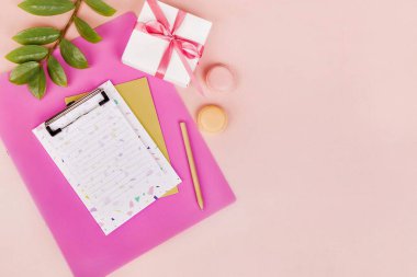 Planlı düz yatak, boş ataç tahtası, kalem, hediye kutusu, yeşil yaprak, badem kurabiyesi, pembe sırtı.