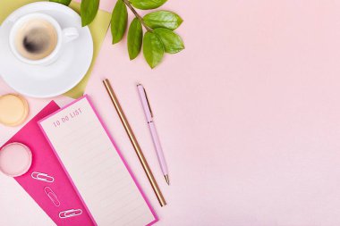 Liste, kalem, bir fincan espresso, yeşil yaprak, pembe sıralı.