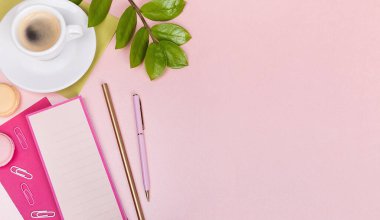 Planlayıcı, kalem, bir fincan espresso, yeşil yaprak, pembe sıralı