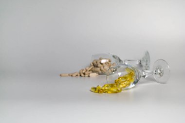 Beyaz arka planda kapsüllerle dolu iki bardak.