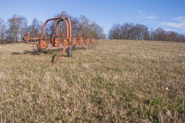 Çimleri biçmek için bir tarım makinesi. Tepedeki çayırlar. Orman uzakta..