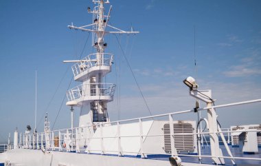 Beyaz bir geminin büyük metal direği. Bariyer ve gemi güvertesi. Güneşli, yaz günü.