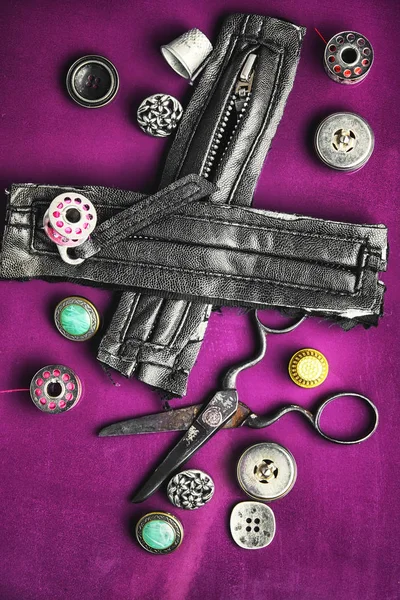 Швейна фурнітура на фіолетовому фоні — стокове фото