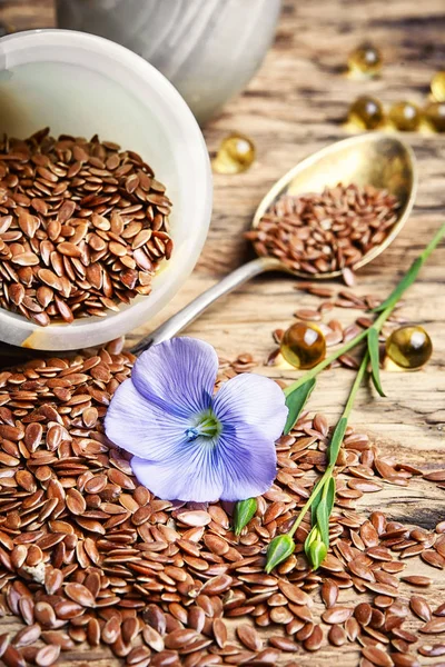 Flax seeds in spoons and bowl — Stock Photo, Image