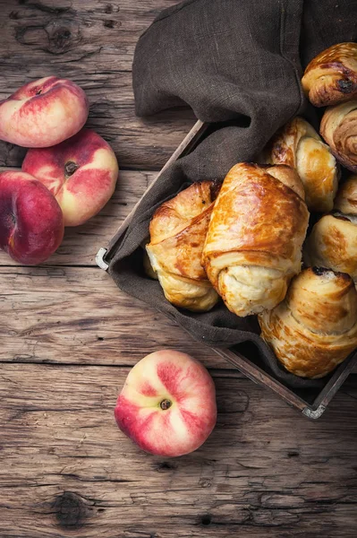 Tasty croissants with peaches — Stock Photo, Image