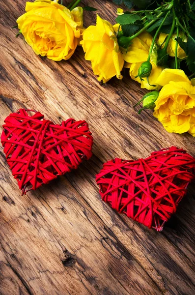 Jarní květiny a symbolická červená srdce — Stock fotografie