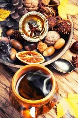 Sonbahar yaprakları ve koni arka plan üzerinde sonbahar çay Kupası