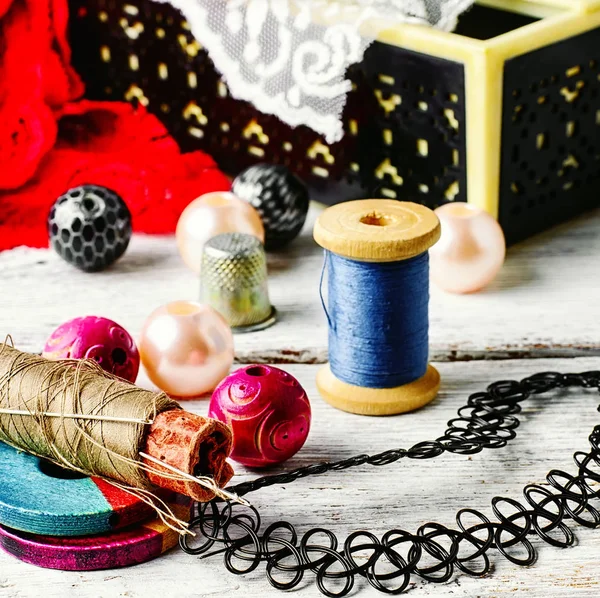 Jewelry and a sewing tool — Stock Photo, Image
