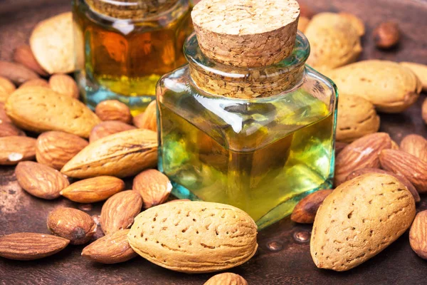 Almond oil in bottle and nuts