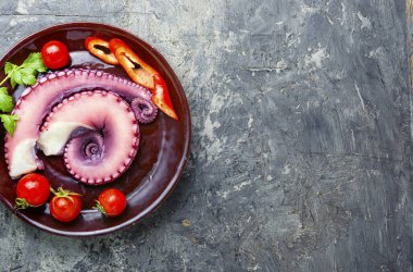 Tentacles of raw octopus.Seafood.Raw octopus ready for cooking.Flat lay with copy space clipart