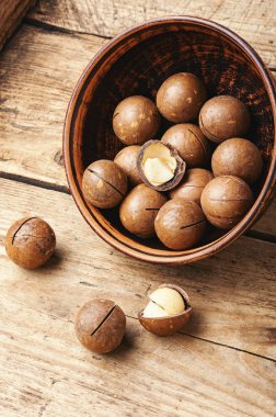 Eski ahşap masada organik Macadamia fındığı.