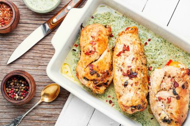 Rolled chicken breast stuffed with spinach and pepper.Homemade grilled chicken breast in with herbs on wooden table clipart