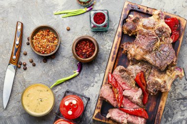 Tahta mutfak tahtasının üzerinde sulu, orta boy biftek dilimleri.