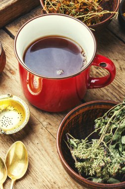 Ahşap bir arka planda şifalı bitkilerden yapılmış çay.