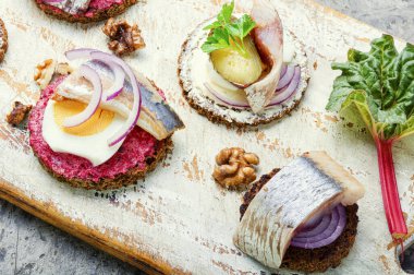Küçük sandviçler ya da tuzlanmış ringa balığı, pancar ve soğanlı bruschettalar.