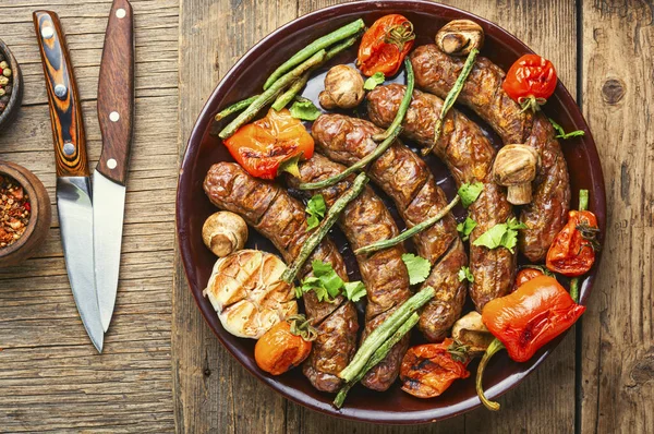 Delicious german sausages with grilled mushrooms and tomatoes.BBQ with sausage