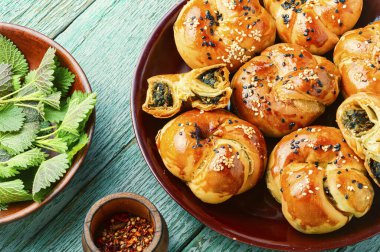 Ev yapımı ısırgan otu ve ıspanaklı çörek. Bitkilerle birlikte taze pişmiş çörekler.