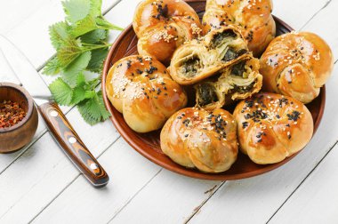 Beyaz arka planda ev yapımı ısırgan otu ve ıspanaklı çörek.