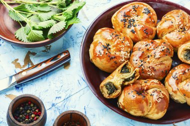 Ev yapımı ısırgan otu ve ıspanaklı çörek. Bitkilerle birlikte taze pişmiş çörekler.