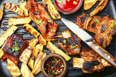 Izgarada dana kaburgası ve ızgara panoda kızarmış patates. Izgara kaburga ve patates kızartması.