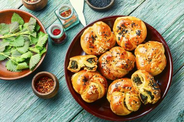 Ev yapımı ısırgan otu ve ıspanaklı çörek. Bitkilerle birlikte taze pişmiş çörekler.