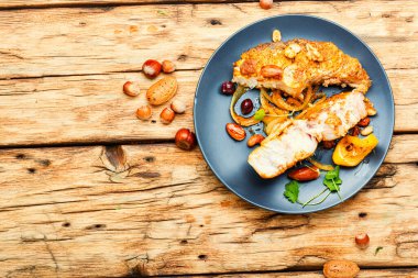 Ahşap masada fındık soslu kavrulmuş gümüş sazan balığı. Cevizli balık bifteği.