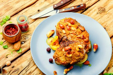 Ahşap masada fındık soslu kızarmış gümüş sazan balığı.