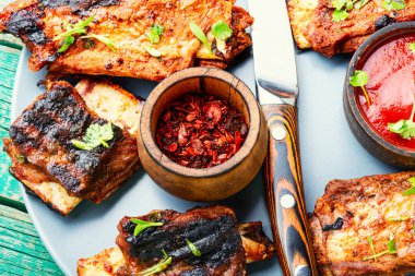 Eski ahşap bir masada domates soslu kızarmış et kaburgası.