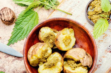 Bitki ve ısırgan otlarıyla doldurulmuş fırında patates.