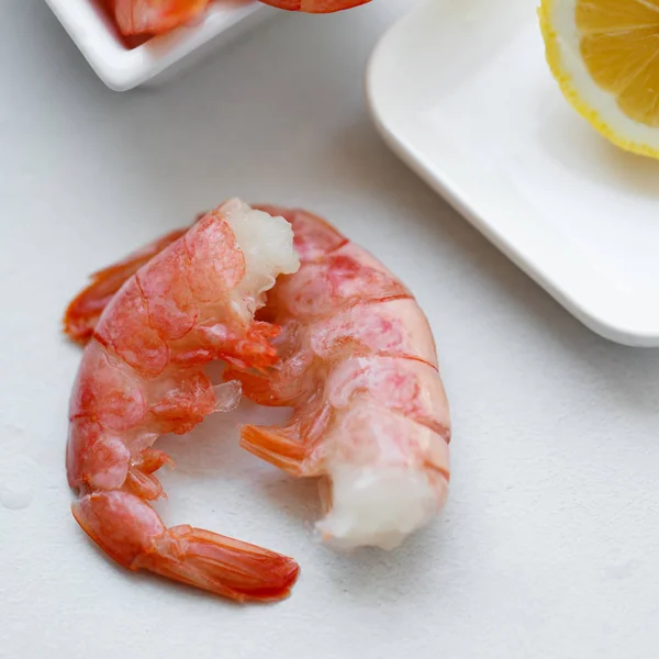 Row tiger shrimp with lemon on white — Stock Photo, Image