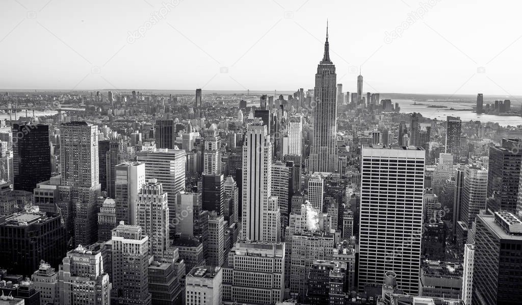 Aerial view to Lower Manhattan downtown skyline with famous Empire State Building and skyscrapers at sunset, New York City, USA.