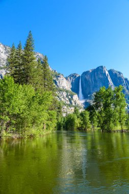 Reflection in Merced River of Yosemite waterfalls and mountain landscape, Yosemite National Park, California, USA. clipart