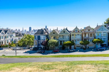 Boyalı bayanlar güzel manzarasına, renkli Victoria evler doğal Alamo Meydanı yakınında bir satırda, mavi gökyüzü ile bir yaz gününde San Francisco, California, ABD yer