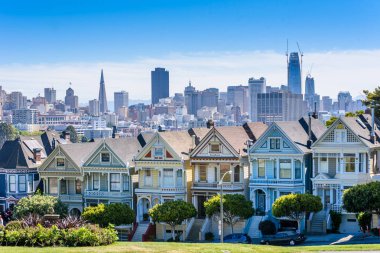 Boyalı bayanlar güzel manzarasına, renkli Victoria evler doğal Alamo Meydanı yakınında bir satırda, mavi gökyüzü ile bir yaz gününde San Francisco, California, ABD yer