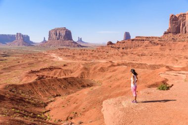 Toprak yolda Monument Valley, ünlü Navajo Buttes kabile Park, Utah - Arizona, ABD doğal sürücü üzerinde duran kadın. 