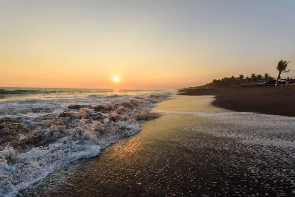 Plaj Monterrico, Guatemala siyah kum ile gün batımında.