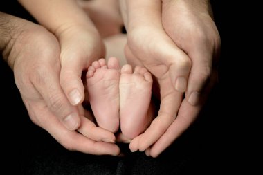 Yeni doğan bebek ayaklarda üst eller - ebeveynlerin çocuklarıyla birlikte mutlu aile anları