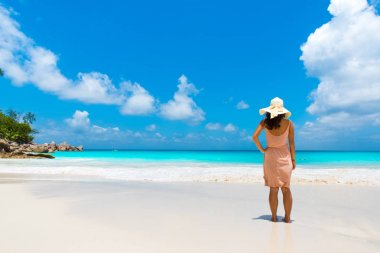 Genç kadının Anse Georgette Praslin, Seyşel Adaları, plajda durup arkadan görünüş.