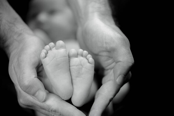 Newborn baby feet in parents hands