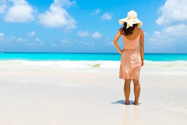位于塞舌尔普拉兰岛的乔其海滩上的年轻女子的后景色 — 图库照片