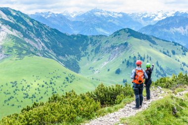 Hikers in beautiful landscape of Alps in Germany - Hiking in the mountains clipart