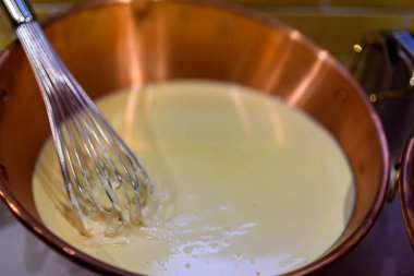 Bakır kase, eriyen beyaz çikolata ve kepçe ile çikolata hazırlama 