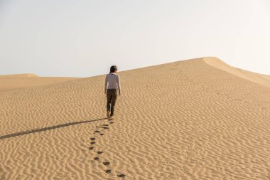 Gran Canaria, İspanya kum tepeleri üzerinde yürüyen kız