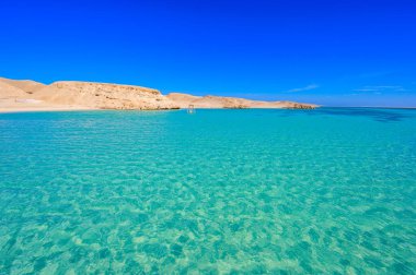 Orange Bay Sahili kristal berrak gök mavisi suyu ve beyaz plajlı - dinlenmek için suda hamak - Giftun adası, Mahmya, Hurghada, Kızıldeniz, Mısır 'ın cennet kıyıları.