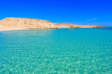 Orange Bay Sahili kristal berrak gök mavisi suyu ve beyaz plajlı - dinlenmek için suda hamak - Giftun adası, Mahmya, Hurghada, Kızıldeniz, Mısır 'ın cennet kıyıları.