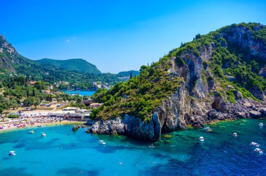 Agios Spiridon Plajı kristal berrak gök mavisi suyu ve güzel manzara manzaralı beyaz plajı - Paleokastritsa, İyon takımadası, Yunanistan 'daki Korfu adasının cennet kıyısı.