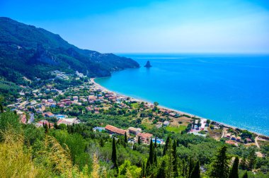 Agios Gordios Sahili kristal berrak gök mavisi suyu ve güzel dağ manzaralı beyaz plajı - Korfu adasının cennet sahili, İyon takımadası, Yunanistan.